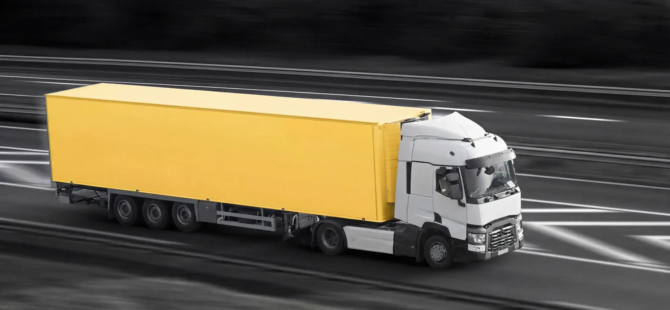 Freight truck with a yellow trailer at speed on an open motorway